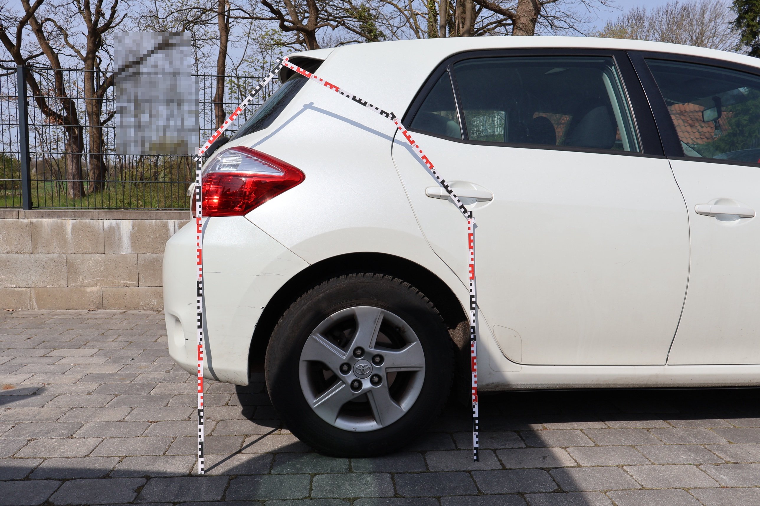 Vermessung des Heckschadens am Toyota Auris mit Messlatten bei der Begutachtung in Celle